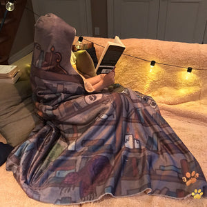 bookstagrammer wearing her cozy emposia hooded blanket while reading a book in her nook 