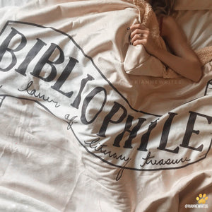 bibliophile covered in an emposia sherpa hooded blanket for book lovers